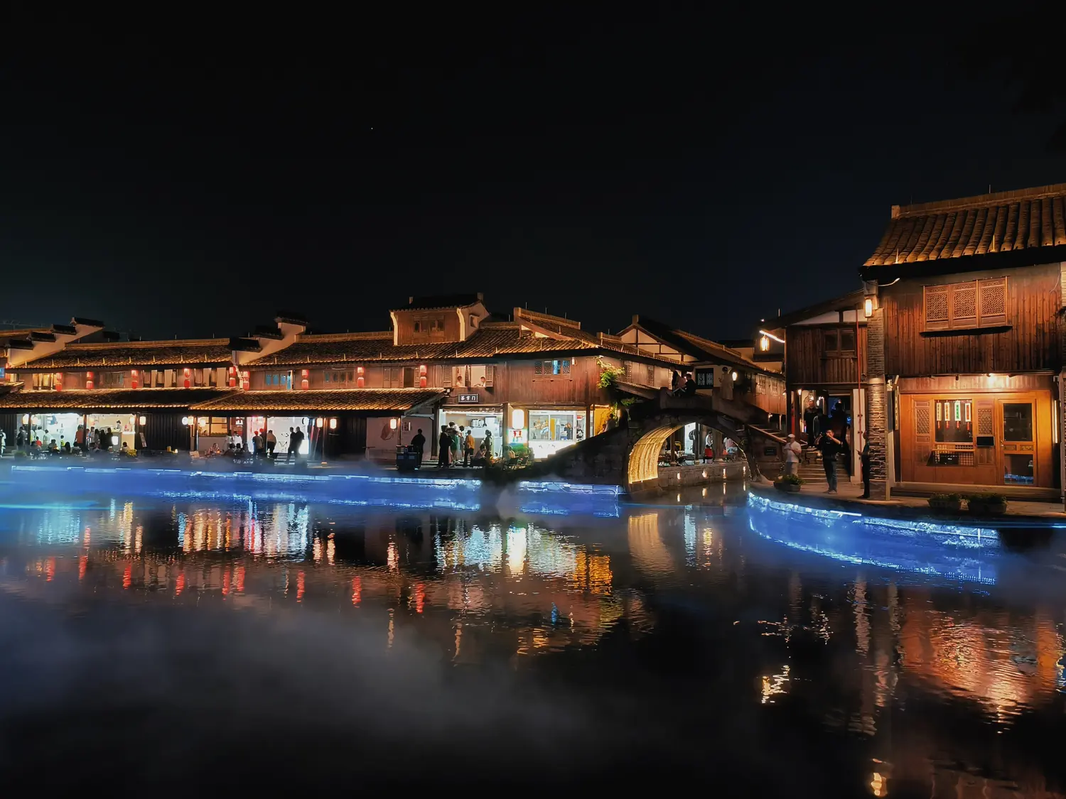 Night view of a Keqiao old-town canal waterfront with illuminated buildings and bridge